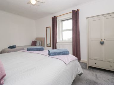 A bedroom with two beds and a wardrobe at 3 Nixon Terrace Broughton Moor near Maryport