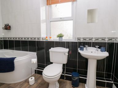 A bathroom with a bathtub toilet and sink at 3 Nixon Terrace Broughton Moor near Maryport
