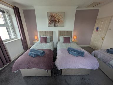 A bedroom with two beds and a lamp at 3 Nixon Terrace Broughton Moor near Maryport
