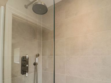 A tiled shower area with a rain shower head and hand shower at The Hollow in West Woodburn