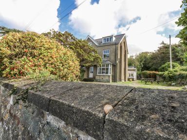 A house with glass windows and a garden at Tawelfan in Llwyngwril