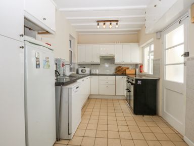 A kitchen with appliances and cabinets at Tawelfan in Llwyngwril