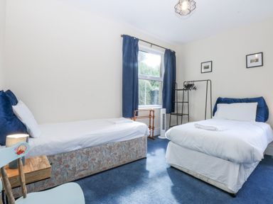 A bedroom with two beds and a window at Tawelfan in Llwyngwril