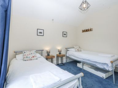 A bedroom with two beds and nightstands at Tawelfan in Llwyngwril