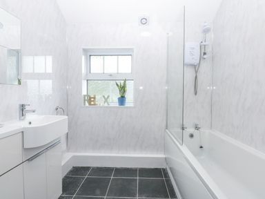A bathroom with a sink, bathtub, and shower at Tawelfan in Llwyngwril