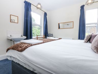 A bedroom with a bed and sink at Tawelfan in Llwyngwril