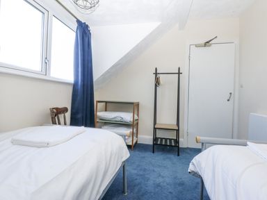 A bedroom with two beds and a hanging rack at Tawelfan in Llwyngwril