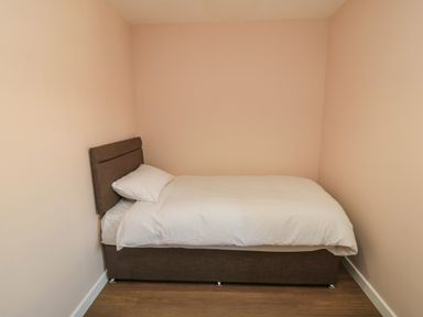 A small bedroom with a single bed and white bedding at 31A The Green in Scalby