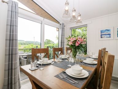 A dining room with a set table and flowers on the table at Eden Fields Lodge in Cupar Fife