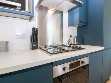 A kitchen countertop with a gas stove knife block toaster and built in oven at Eden Fields Lodge in Cupar Fife