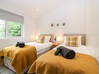 A bedroom with two single beds and yellow blankets at Eden Fields Lodge in Cupar Fife