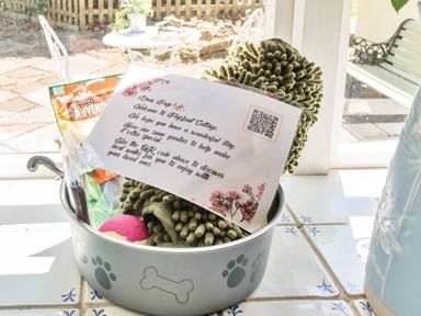 A dog bowl with toys and treats along with a welcome note at 2 Pigsfoot Cottages Ash Thomas near Halberton, Devon