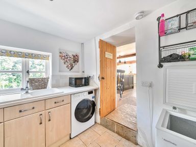 A kitchen with a sink and washing machine at 2 Pigsfoot Cottages Ash Thomas near Halberton, Devon