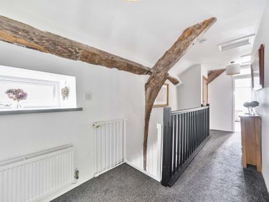 A hallway with wooden beams and a window at 2 Pigsfoot Cottages Ash Thomas near Halberton, Devon