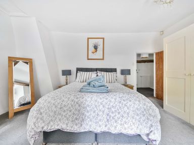 A bedroom with a bed and a mirror at 2 Pigsfoot Cottages Ash Thomas near Halberton, Devon