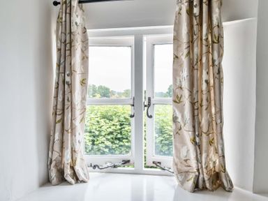A window with curtains in a living room at 2 Pigsfoot Cottages Ash Thomas near Halberton, Devon