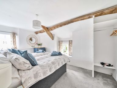 A bedroom with a bed and shelf at 2 Pigsfoot Cottages in Ash Thomas near Halberton, Devon