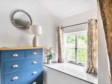 A bedroom with a chest of drawers and a mirror at 2 Pigsfoot Cottages near Halberton, Devon