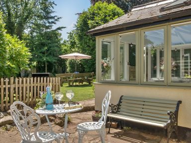 A garden with a table and chairs at 2 Pigsfoot Cottages Ash Thomas near Halberton, Devon