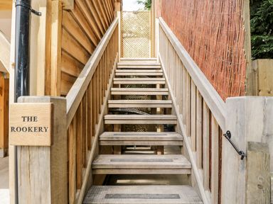 Wooden outdoor staircase with handrails and a sign saying The Rookery at The Rookery in Fulbrook near Burford