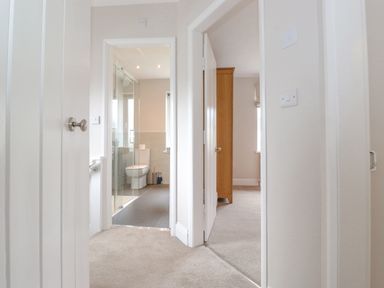 A hallway with doors leading to a bathroom and a bedroom at 1 Millbank in Keswick