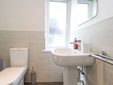 A bathroom with a toilet sink a window and a towel rail at 1 Millbank in Keswick