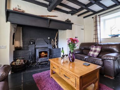 A living room with a fireplace leather sofa and wooden coffee table at Pen y Bont Near Mallwyd
