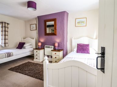 A bedroom with two single beds and bedside tables with lamps at Pen y Bont Near Mallwyd