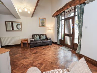 A living room with a sofa and lamp at Horse and Farrier Barn in Newton in Cartmel near Cartmel