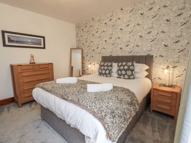 A bedroom with a bed and a chest of drawers at Horse and Farrier Barn in Newton in Cartmel near Cartmel