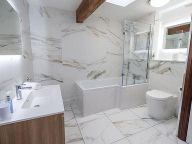 A bathroom with a bathtub, toilet, and sink at Horse and Farrier Barn in Newton in Cartmel near Cartmel