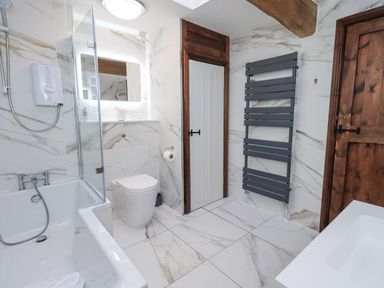 A bathroom with a bathtub and shower at Horse and Farrier Barn in Newton in Cartmel near Cartmel
