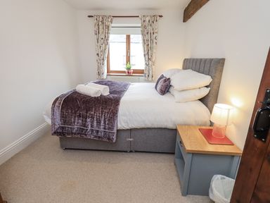 A bedroom with a bed and window at Horse and Farrier Barn in Newton in Cartmel near Cartmel