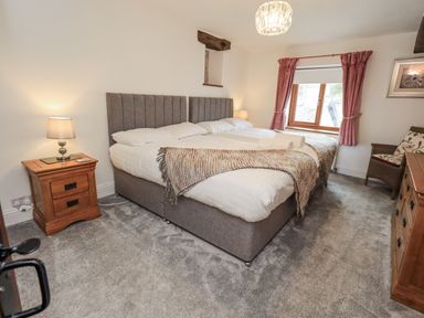 A bedroom with a bed and lamp at Horse and Farrier Barn in Newton in Cartmel near Cartmel