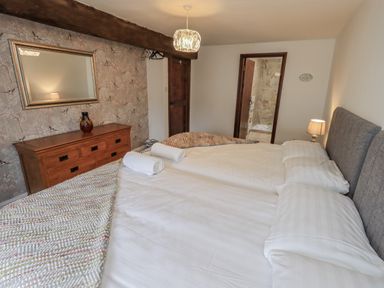 A bedroom with two beds and a dresser at Horse and Farrier Barn in Newton in Cartmel near Cartmel
