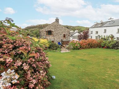 A garden with flowers and grass at Horse and Farrier Barn in Newton in Cartmel near Cartmel
