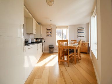 A kitchen with cabinets countertop dining table and chairs at 23 Tibby's Way Southwold
