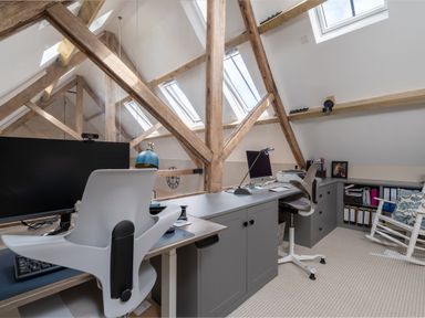 An office with two desks two chairs computers filing cabinets and wooden beams in the ceiling at The Stables in Wheatley