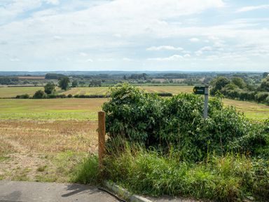 A countryside view with fields trees and a footpath sign at The Stables in Wheatley