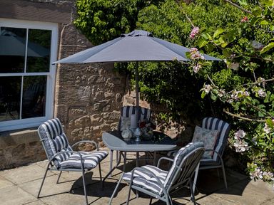 A garden seating area with a table and chairs at Wonderland in Tweedmouth, Berwick-Upon-Tweed