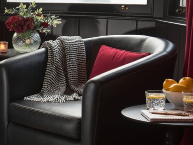 A sitting room with an armchair and table at Wonderland in Tweedmouth, Berwick-Upon-Tweed