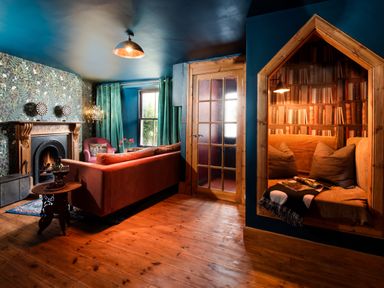 A living room with a fireplace and book nook at Wonderland in Tweedmouth, Berwick-Upon-Tweed