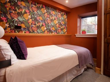 A bedroom with a bed and wallpaper at Wonderland in Tweedmouth, Berwick-Upon-Tweed