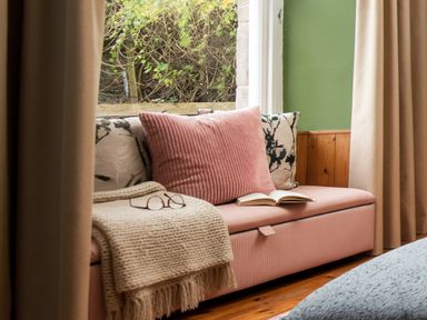 A living room with a couch and a book on a table at Wonderland in Tweedmouth, Berwick-Upon-Tweed