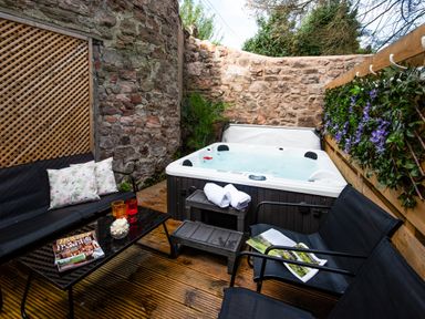 An outdoor area with a hot tub and seating at Wonderland in Tweedmouth, Berwick-Upon-Tweed
