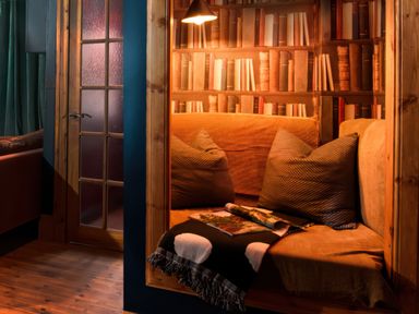 A reading nook with a sofa and bookshelf at Wonderland, Tweedmouth, Berwick-Upon-Tweed