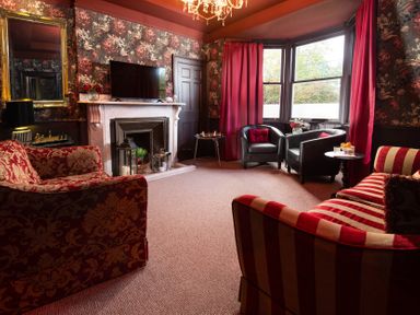 A living room with a sofa, armchairs and a fireplace at Wonderland in Tweedmouth, Berwick-Upon-Tweed