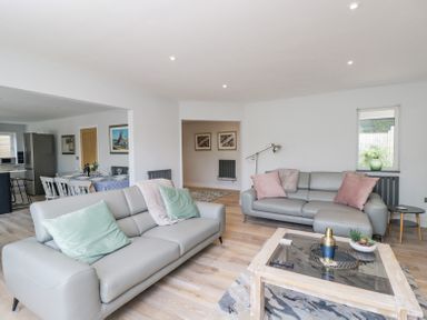 A living room with two grey sofas and a glass coffee table showing decorative items at Greystones in Upton St Leonards