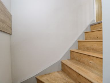 A wooden staircase with light wood steps and white walls at Greystones in Upton St Leonards