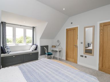 A bedroom with a bed a window seat and a small desk with a chair at Greystones in Upton St Leonards